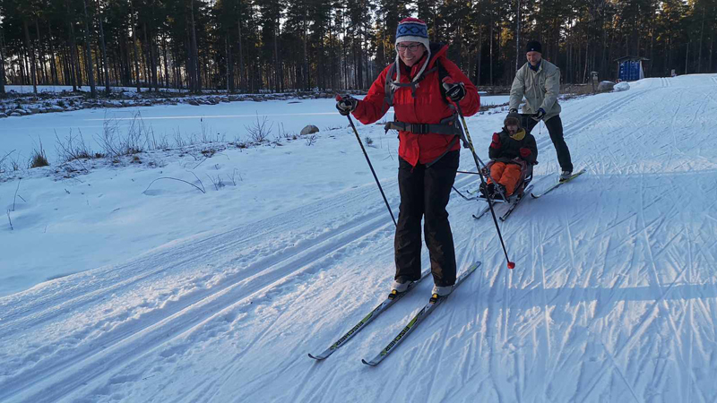 Vilhelm Rahm gläds på snön tillsammans med mamma Jennie och pappa Fredrik. Farten i nedförsbackarna är extra roliga tycker Vilhelm!
