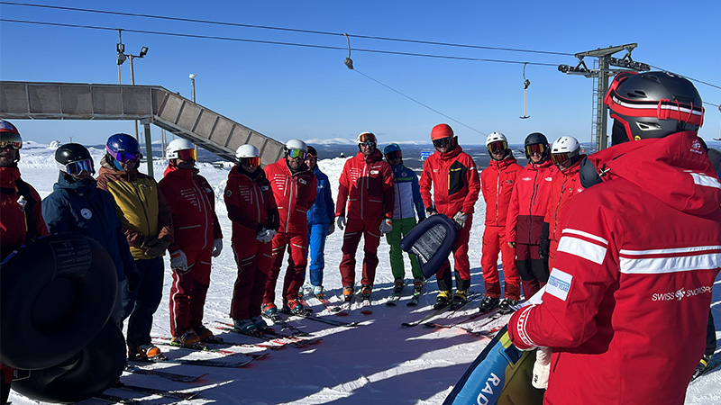 Grupp alpina skidåkare som får instruktioner i backen. Foto: Magnus Löfstrand.